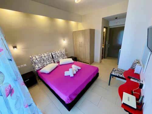 a bedroom with a pink bed and a couch at Octopus in Vasiliki