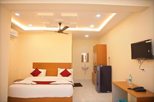 a hotel room with a bed and a tv at Jay & Jas Hotel in Tirupati