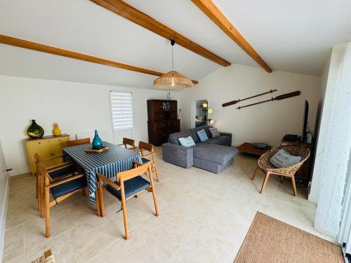 un salon avec une table et un canapé dans l'établissement La Parenthèse Olonnaise & Maison Familiale, à LʼÎle-dʼOlonne