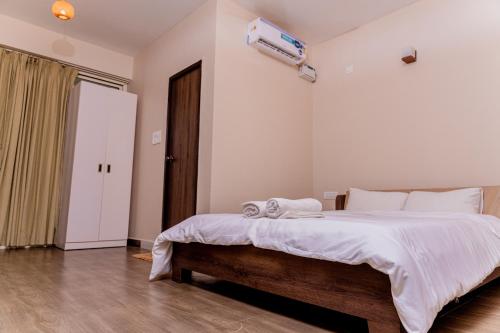 a bedroom with a large bed with white sheets at Casa Aqua Mandrem in Mandrem