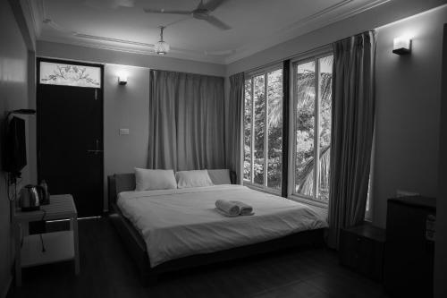 a bedroom with a bed and a large window at Casa Aqua Mandrem in Mandrem