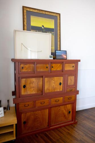 a wooden dresser with a mirror on top of it at Appartement dijk Middelkerke met zeezicht in Middelkerke