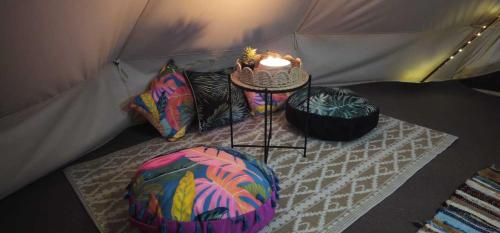 a tent with a table and a candle in it at Stonehenge Shepherds Huts in Durrington