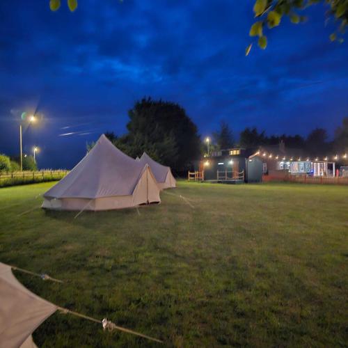 a white tent in a field at night at Stonehenge Shepherds Huts in Durrington