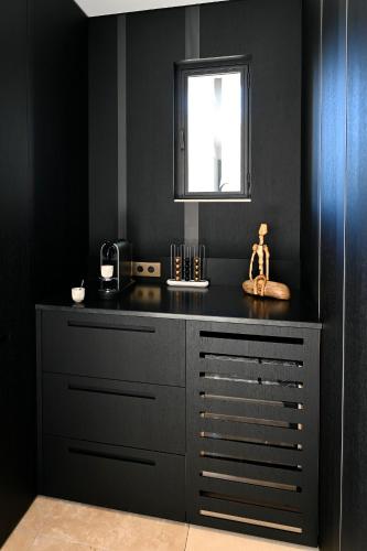 a kitchen with a black counter and a window at La Suite Gordes in Gordes