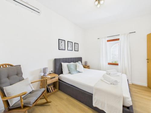 a bedroom with a bed and a chair at Apartmani Jesenova in Selce