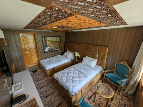 an overhead view of a bedroom with two beds and a chair at The Jade Palace, Hunza in Karimabad Hunza