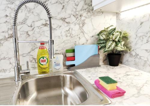 a kitchen sink with a sponge and a detergent at Peak District Cottage in Buxton