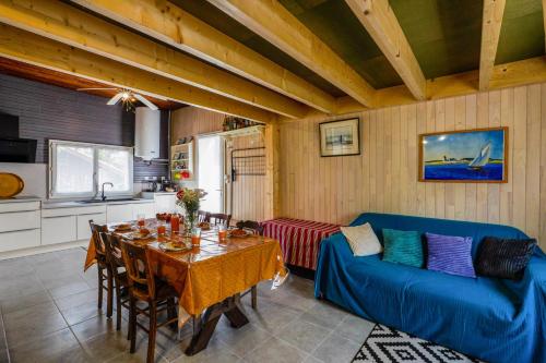 un salon avec une table et un canapé bleu dans l'établissement Maison avec jardin et terrasse - 200m plage et forêt, à Mimizan-Plage
