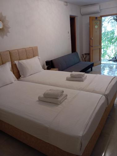 a bedroom with two beds and a couch at Colors Apartments Pilio in Afissos