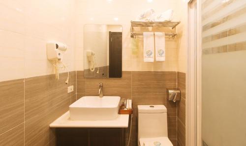 a small bathroom with a sink and a toilet at Iloilo Gateway Hotel and Suites by RedDoorz in Pavia