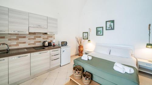 a kitchen with a bed and a sink in a room at Casetta Carlotta by Rentbeat in Ostuni
