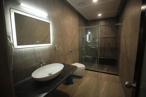 a bathroom with a sink and a toilet and a mirror at Nalluri Garden Resort in Kottapatnam