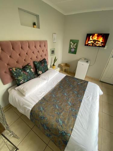 a bedroom with a large bed with a large headboard at Mbathos guesthouse in Durban