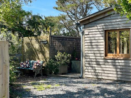 a bench in a yard next to a building at The Garden Room - Cabin on The Lizard in Cury
