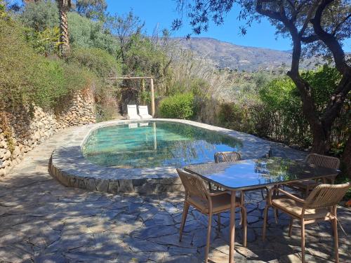 a small pool with a table and chairs next to it at Casa Champasak in Órgiva
