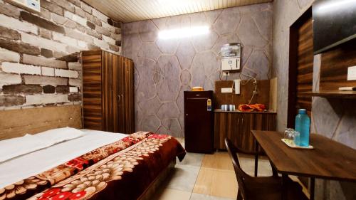 a bedroom with a bed and a table and a desk at SYL HOTELS One - Comfortable and Secure Stays in Phagwāra