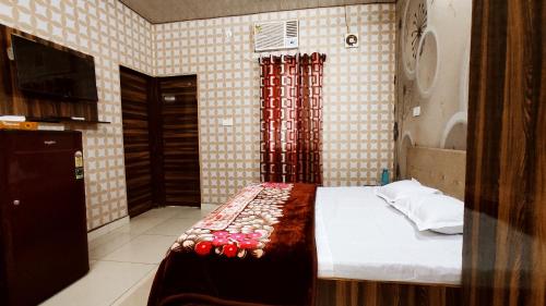 a bedroom with a bed and a television in it at SYL HOTELS One - Comfortable and Secure Stays in Phagwāra