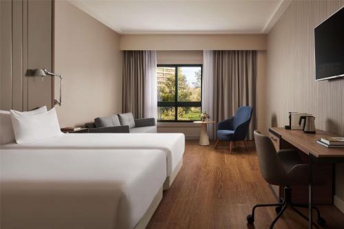 a hotel room with a bed and a desk at NH Lisboa Campo Grande in Lisbon