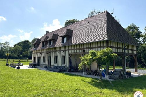un grand bâtiment avec un toit en gambrel dans l'établissement Villa Normande - Entre Terre et Mer, à Tourgéville