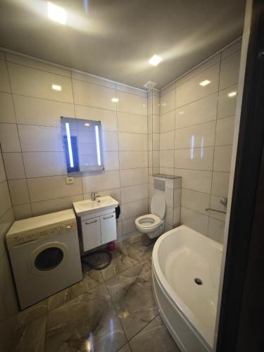 Un baño con inodoro, lavabo y bañera. en Sunny Studio Near the Sea, en Kobuleti
