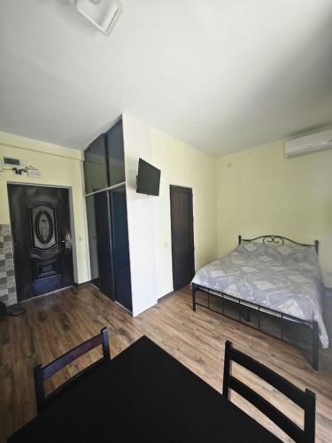 Un dormitorio con una cama y un televisor. en Sunny Studio Near the Sea, en Kobuleti