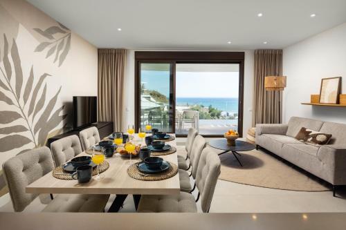a living room with a dining table and chairs at Luxury 3bed-Apartment with Stunning Sea Views in Rincón de la Victoria