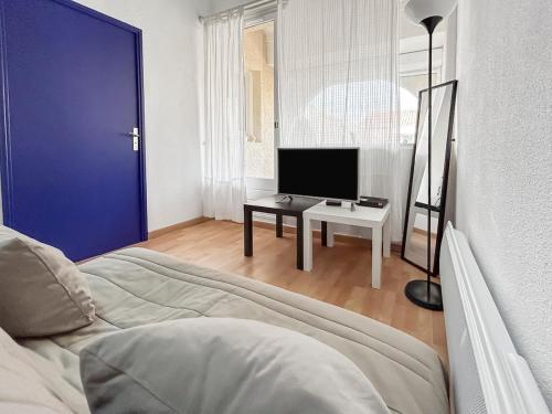 a living room with a couch and a tv at Pied-à-terre idéal entre mer et port in Mauguio
