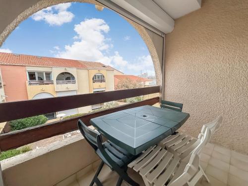 a table and chairs on a balcony with a window at Pied-à-terre idéal entre mer et port in Mauguio