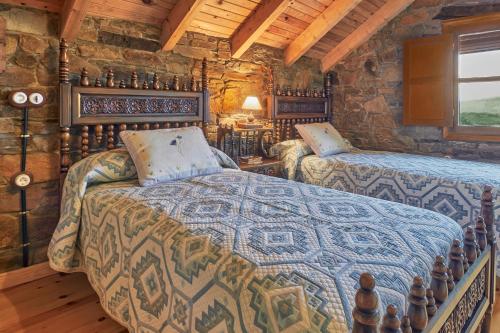 a bedroom with two beds in a log cabin at Casa Rural Tio Eloy in Fabero