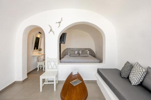 a living room with a bed and a couch at Ilioperato Hotel in Imerovigli
