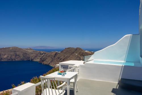 a white balcony with a view of the blue ocean at Ilioperato Hotel in Imerovigli