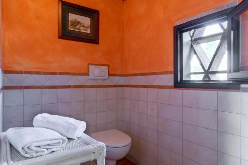 ein Badezimmer mit Toilette und Fenster in der Unterkunft GLI SPILOCCHI 16, Emma Villas in Gambassi Terme