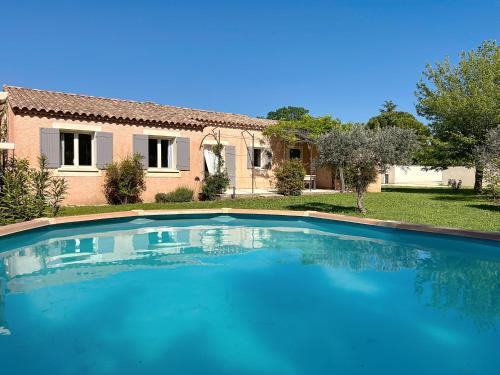 une grande piscine bleue devant une maison dans l'établissement Casa du Luberon, à Maubec