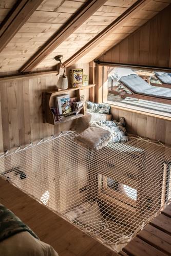 une grande cage à oiseaux dans une pièce avec une fenêtre dans l'établissement La Cabane le Cœur de Xanet, à Bassussarry