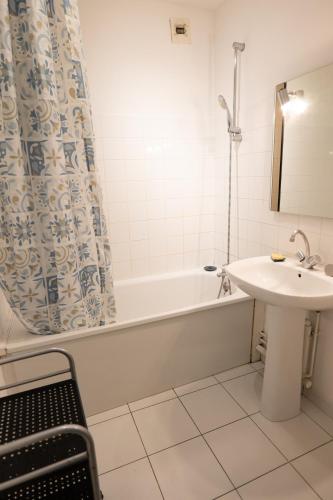 une salle de bain avec un lavabo et une baignoire et un lavabo dans l'établissement Nantes appartement plain pied proche Beaujoire, à Nantes