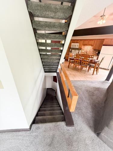 a staircase leading to a dining room with tables at Treehouse Treetop Village66-3bed3bapools-8pp in Four Seasons