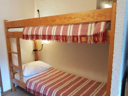 un lit superposé dans une chambre avec un oreiller et une échelle dans l'établissement Comfort and nature - Ideal stay 200m from slopes, à Saint-Jean-dʼAulps