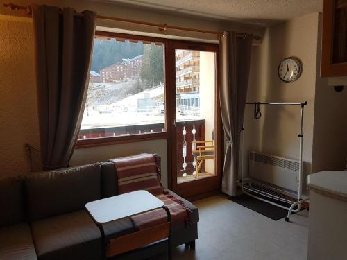 un salon avec un canapé et une grande fenêtre dans l'établissement Comfort and nature - Ideal stay 200m from slopes, à Saint-Jean-dʼAulps