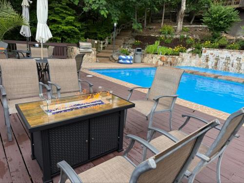 a table and chairs next to a swimming pool at Treehouse Treetop Village66-3bed3bapools-8pp in Four Seasons