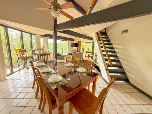 a dining room with a table and chairs and a staircase at Treetop Village-3bed3bathpoolsdocks6-8pp in Four Seasons