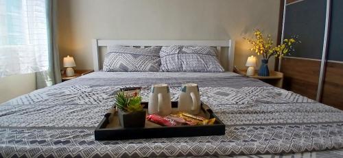 a tray of food sitting on top of a bed at Mike's Residence at Marina Spatial - Dumaguete City in Piapi