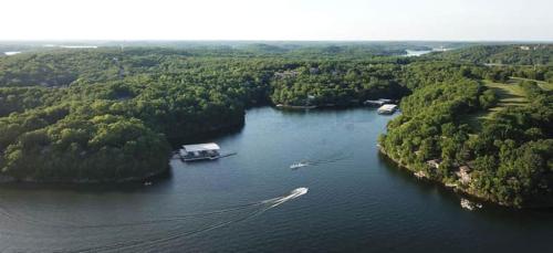 an aerial view of a lake with a house and a boat at Treetop Village-3bed3bathpoolsdockpickleball in Four Seasons