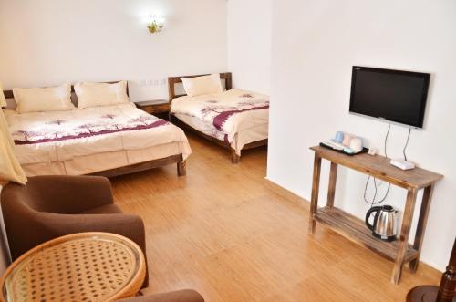 a living room with a couch and a tv at Tourist Courtyard Hotel in Jianchuan