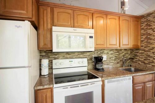 a kitchen with a white stove and a microwave at Treetop Village-3bed3bathpoolsdockpickleball in Four Seasons