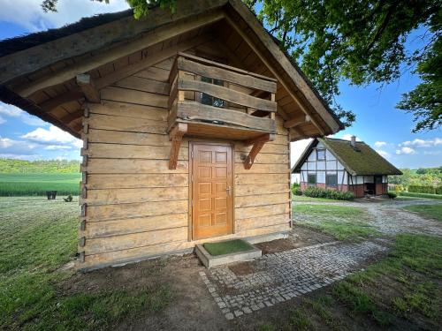 a small wooden building with a door in a field at Domki Machnice in Machnice