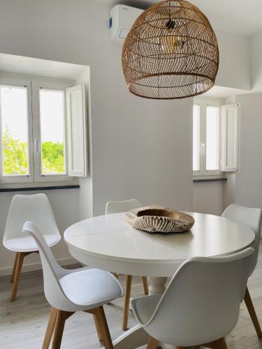 a white dining room with a white table and chairs at Clover House Tavira in Tavira