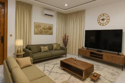 a living room with a couch and a flat screen tv at Lekki Luxe 4BR Retreat in Ikota