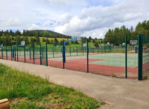 a tennis court with two tennis courts at L' Éclat des Sommets en face et aux pieds des pistes in Superdevoluy