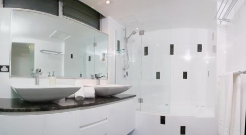 a white bathroom with two sinks and a mirror at Poinciana 112 Bedrooms x3 Free Buggy in Hamilton Island